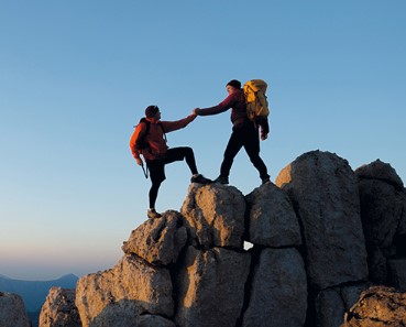 Bergsteiger helfen sich gegenseitig beim erklimmen des Gipfels