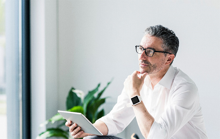 Mann grübelt vor seinem Tablet