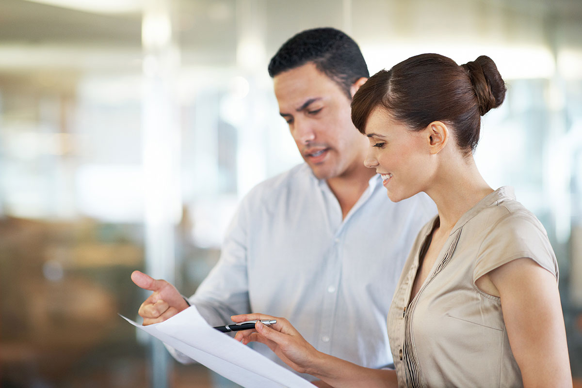 Mann und Frau unterhalten sich über Dokumenten