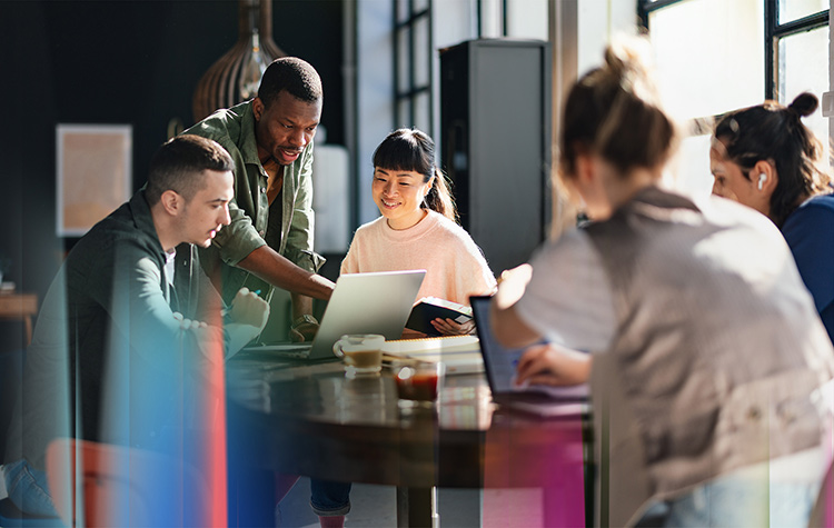 Marketing Mitarbeitende arbeiten miteinander in einem Großraumbüro