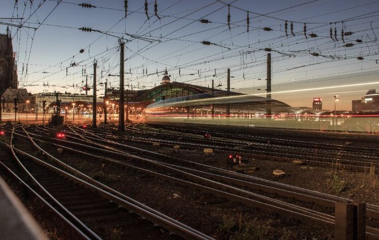 Railway station with tracks and light trails at night