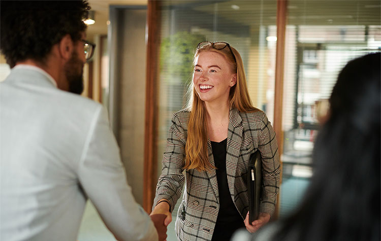 Drei Kollegen begrüßen sich - Berufseinsteiger