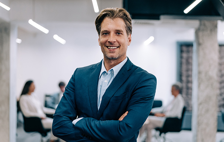 Junger Angestellter schaut freundlich in die Kamera