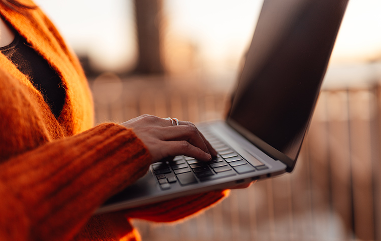 Frau tippt auf ihrem Laptop