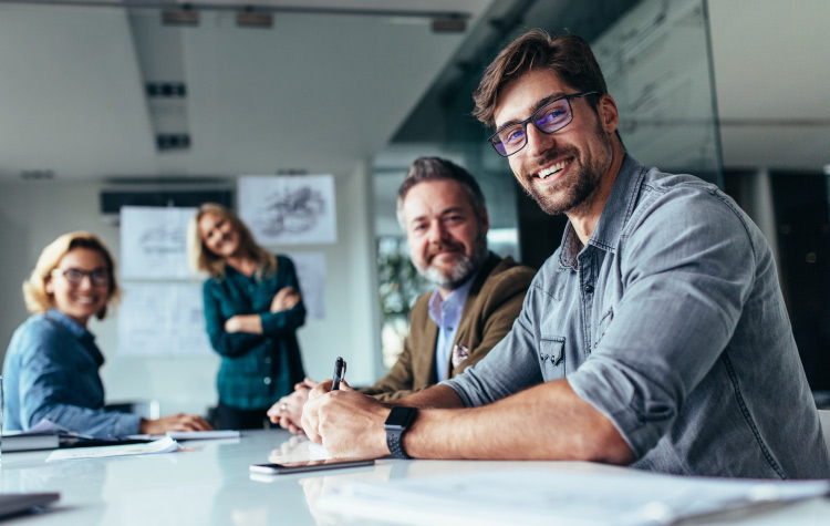 Four employees working together in a meeting room