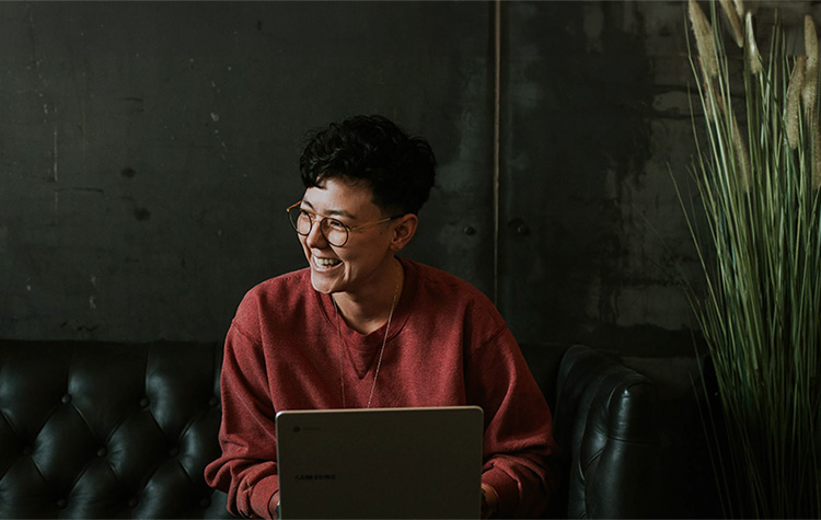 Frau lachend vor Laptop