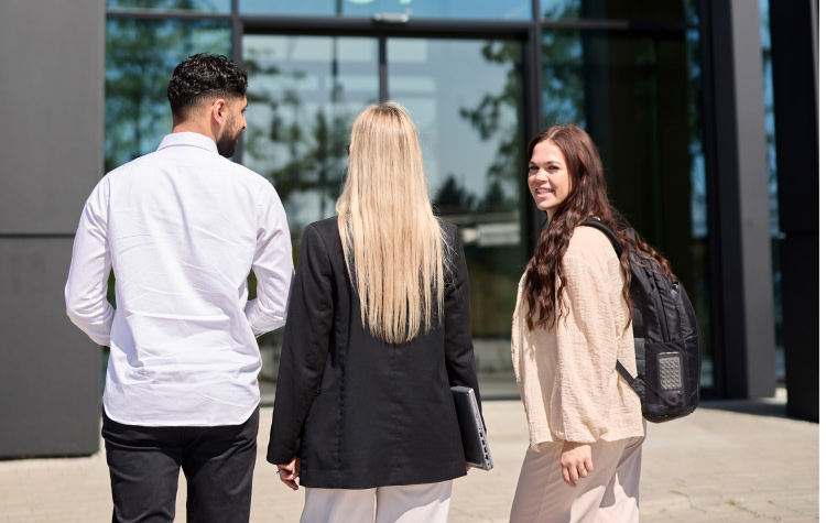 3 Werkstudenten laufen zum Haupteingang