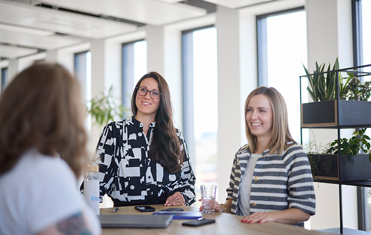 Kolleginnen unterhalten sich im Meetingraum