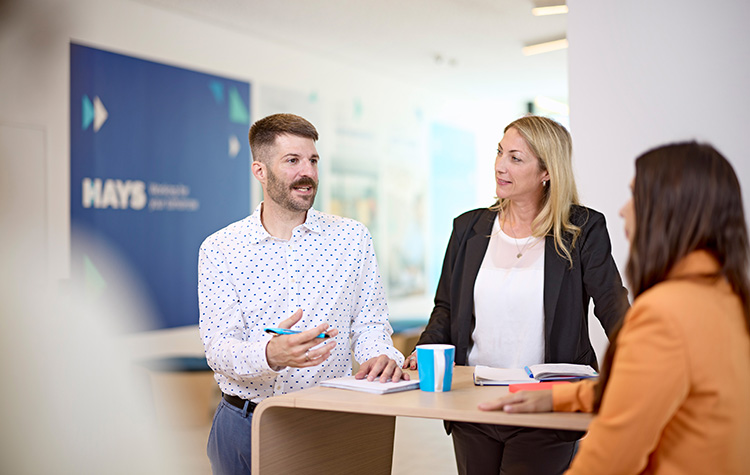 Kollege diskutiert mit 2 Kolleginnen