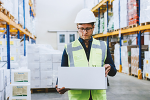 Logistikmitarbeiter steht im Lager und organisiert