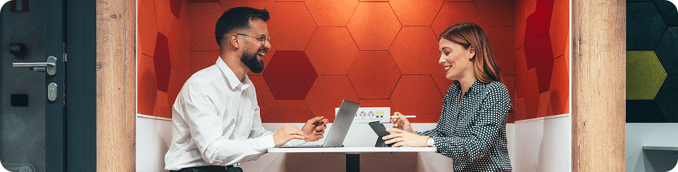 Zwei Kollegen unterhalten sich während sie zusammen arbeiten