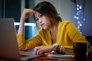 Eine Frau sitzt vor einem Laptop