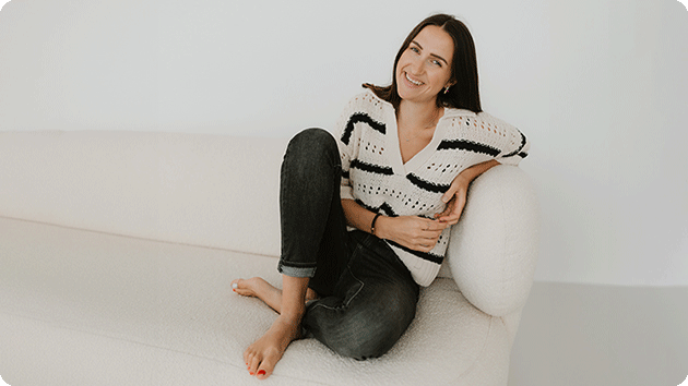 Jana Müller sitzt auf einer weißen Stoffcouch