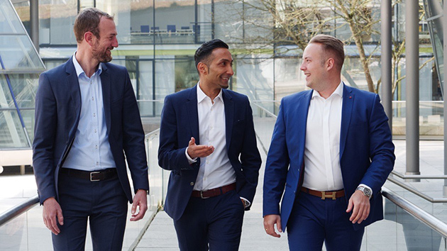 Drei Kollegen laufen nebeneinander