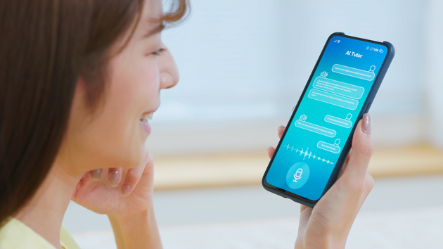 Frau schaut auf ihr Handy und lächelt