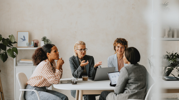Personen sitzen zusammen am Tisch