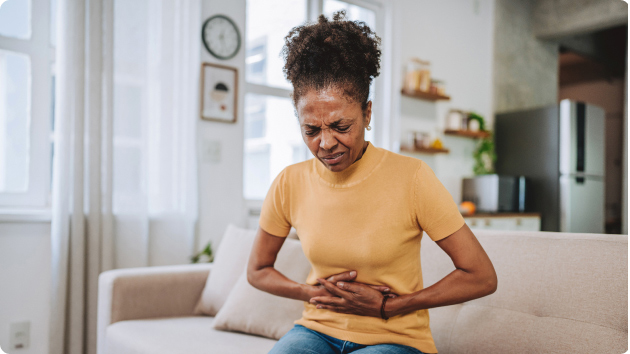 Frau hält sich den Bauch vor Schmerzen