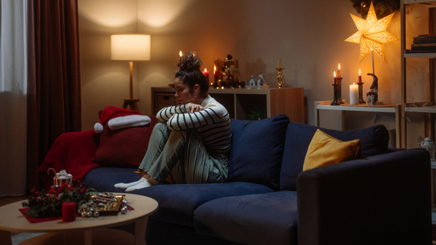 Frau sitzt auf der Couch mit Winterblues