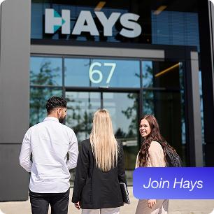 3 Mitarbeitende laufen auf den Haupteingang von Hays zu