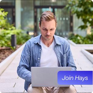 Mitarbeiter sitzt im Hof an seinem Laptop