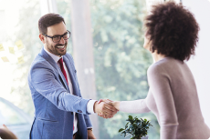 Mitarbeiter und Frau geben sich die Hand auf einen Vertrag