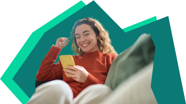 Junge Frau schaut lachen auf ihr Handy
